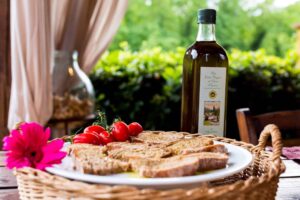 Bottiglia di olio EVO accanto a pane toscano, pronto per una degustazione di olio extravergine d’oliva in agriturismo a Gambassi Terme